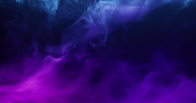 Colored smoke moves beautifully against a black background. Mockup for your logo. Wide angle horizontal wallpaper or web banner. Slow motion.