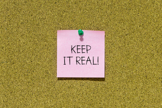 Keep it real text on pink post-it paper pinned on bulletin cork board. This message can be used in business concept about keep it real.