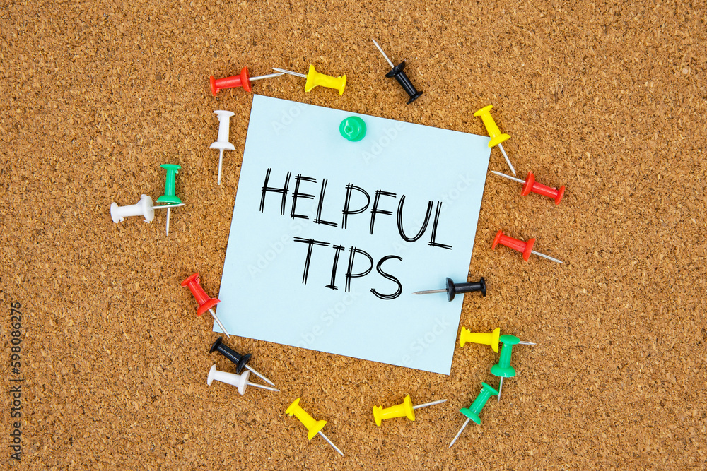 Fototapete Helpful tips text on light blue post-it paper pinned on bulletin cork board surrounding by multi color pins. This message can be used in business concept about tips.