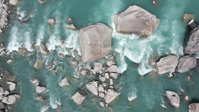 Drone descending over green and glacial water of Indus River, located in Gol valley of Skardu, Gilgit Baltistan, Pakistan. 