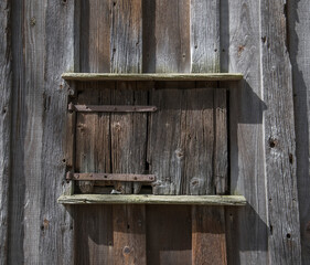 Old wood brown window hatch on a 1700s house, a sunny spring day in Stockholm 