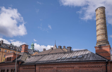 Roof, dorms and chimney on the old royal stable brick houses in the district Östermalm, a sunny...