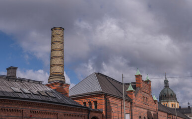 Roof, dorms and chimney on the old royal stable brick houses in the district Östermalm, a sunny spring day in Stockholm