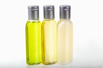 Three small bottles of cosmetics on white background close-up. Shampoo, shower gel, body lotion. Travel, trips, hotels. Cosmetics mockup, advertising