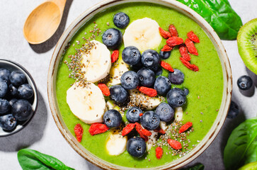 Healthy Green Spinach Smoothie in a Bowl with Banana, Blueberry, Goji, and Chia Seed Toppings, Detox, Vegetarian Food
