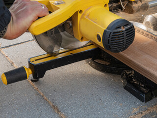Man working with circular blade saw for cutting wood beam. Close up image of hand power tools.