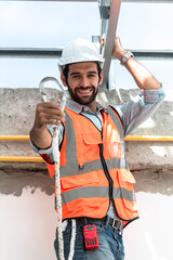 Construction worker men wearing safety sling climbing belt and hardhat while working at height, Engineer working at construction site real estate project.