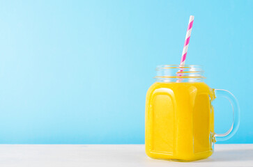 Orange Smoothie in a Jar, Vitamin Drink or Cocktail on Bright Background
