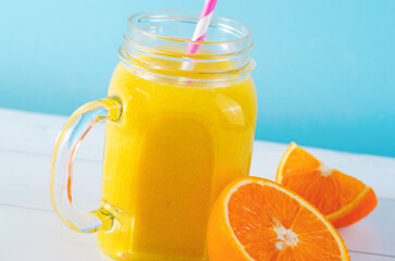 Fototapeta na wymiar Orange Smoothie in a Jar, Vitamin Drink or Cocktail on Bright Background