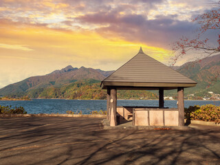 Japan at sunset. Lake Kawaguchiko. Arbor on shore of reservoir. Wooden gazebo at sunset. Lake Kawaguchiko in autumn evening. Japan landscape with mountains. Tour to Kawaguchiko. Nature regions Japan