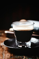 Coffee in glass cup on dark wooden background. Copy space.	