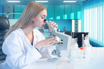 Woman biologist with microscope. Biological laboratory student. Intern at university of...