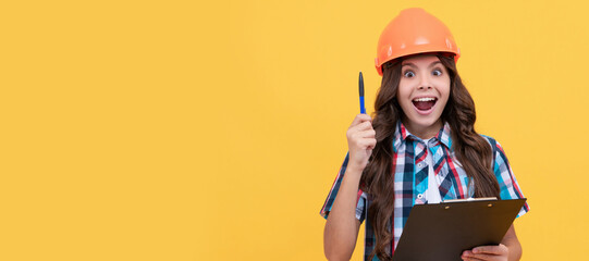 inspired girl in protective hard hat making notes. child in helmet read project. Child builder in helmet horizontal poster design. Banner header, copy space.