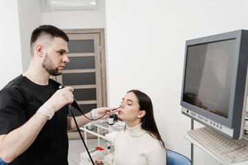 ENT doctor using fibrolaryngoscope to examine and treat nose. ENT specialist diagnoses and treats...
