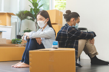 Crisis, Stressed  business due to outbreak of coronavirus, asian young couple wear mask moving new relocation, home no money pay expense mortgage, loan. Unemployed, loss job or debt, bankrupt people.