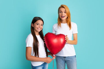 Love mom. Mother and daughter hold heart balloon. Happy mother and daughter holding love heart balloon on blue background.