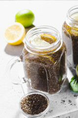 Chia Infused Water with Lemon and Lime in Jars, Healthy Citrus Drink on Bright Background