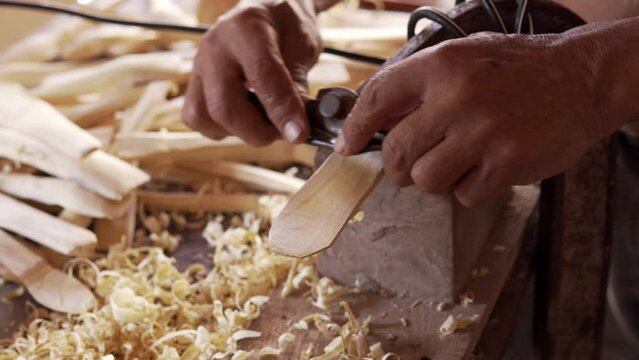 man carving wooden spoon in his house in colombia