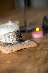 baton de sauge en train de bruler à coté d'une bougie pour activité spirituelle