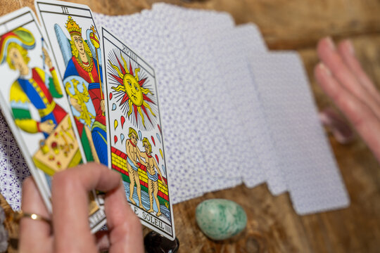 tirage du tarot de Marseille avec la carte du soleil dans la main de la voyante