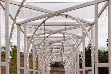 iron structure with arches and light bulbs in the city park