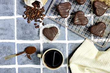 heart shaped chocolate cookies with coffee beans, powder and cup 