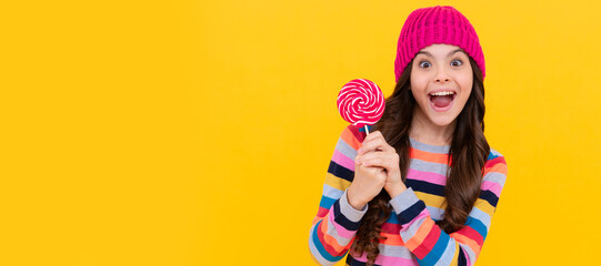 surprised kid girl hold lollipop sweet, copy space, caramel shop. Teenager child with sweets,...