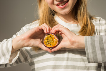 Healthy fresh fruit passion fruit maracuja in the hands of a young girl. Natural food with...
