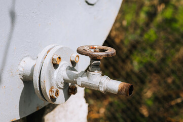 Rusty water valve with an open flange close-up outdoors.