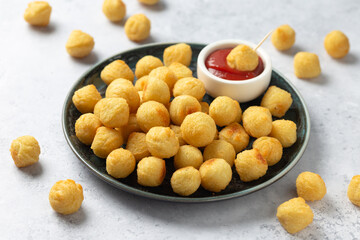 Crispy potato balls with ketchup on rustic plate