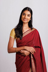 Fototapeta premium Beautiful Indian young woman in traditional saree in studio shot.