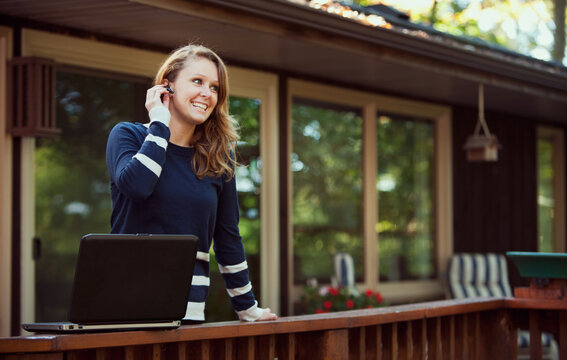 Working: Woman Conferencing On Headset and Laptop