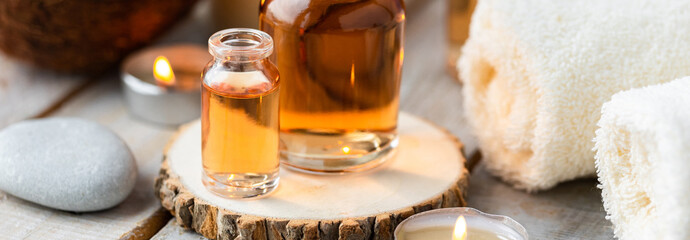 Concept of spa treatment in salon with pure organic natural oil. Atmosphere of relax, detention. Aromatherapy, candles, towel, wooden background. Skin care, body gentle treatment