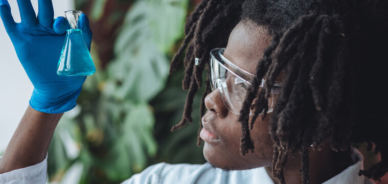 Male African American scientist working in the laboratory making biological test, scientific research. Concept of multiethnic multiracial people in science, professional biologist. Banner