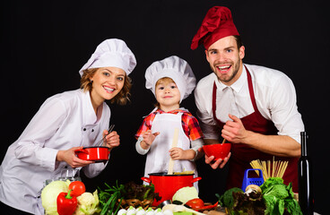 Happy family preparing healthy food together in kitchen. Parents teaching son how to cook healthy meal. Family prepare dinner. Mother, father and son cooking at home. Homemade food and little helper.