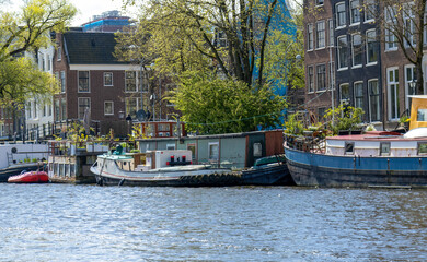 canal in Amsterdam in the spring with boathouse and beautiful sunshine on the water