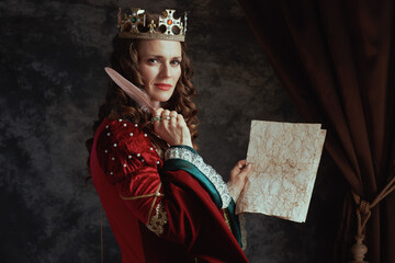 medieval queen in red dress with parchment and crown