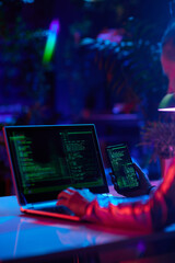 Seen from behind modern woman with laptop developing video game