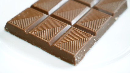 A bar of milk chocolate on a white plate