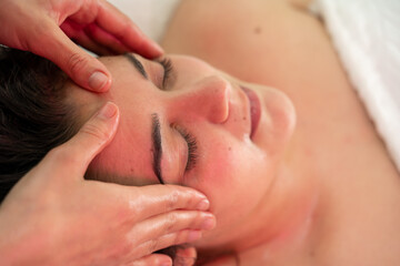 jeune femme brune recevant un massage du visage