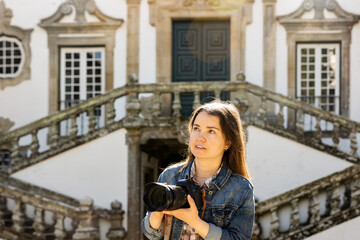 Naklejka na ściany i meble Traveler woman with passion for photography enjoying strolling through courtyard of Mateus Palace while visiting Vila Real in Portugal, photographing baroque architecture with Generative AI