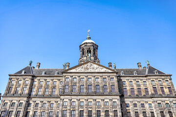 Fototapeta na wymiar Amsterdam, Netherlands - March 28, 2023: The Royal Palace and the New Church surrounding Dam Square in Amsterdam 