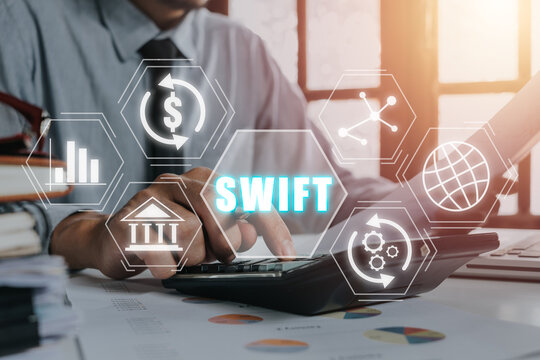 SWIFT, Society for Worldwide Interbank Financial Telecommunications, Business person working on calculator with VR screen swift icon on office desk, Financial Banking regulation concept.