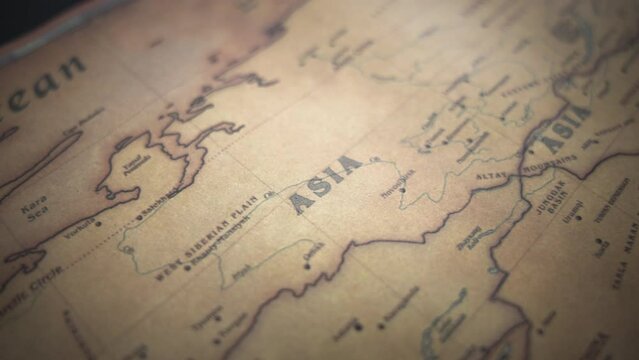 Asia on a vintage political world map. Slow motion, tracking arc shot.  