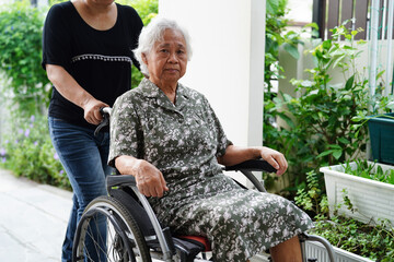Fototapeta na wymiar Caregiver help Asian elderly woman disability patient sitting on wheelchair in hospital, medical concept.