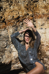Attractive woman in fashion outfit outside. Shadow on face from hand. Outdoor fashion photo of young beautiful lady enjoying spring.
