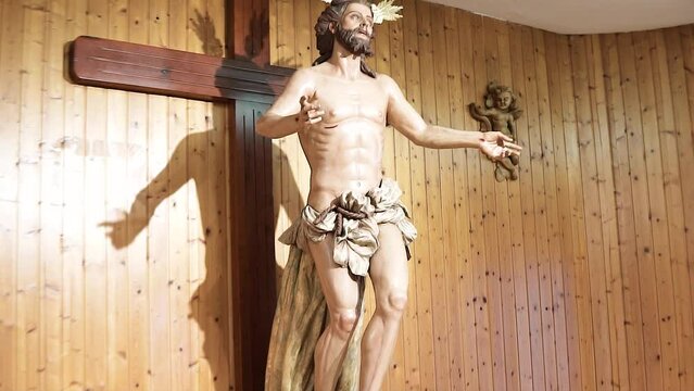 Wooden image of Jesus on the cross, Christ. Wooden wall behind.