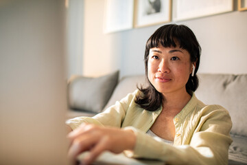 Young Japanese Woman using a laptop on a couch
