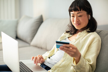 Young Japanese woman online shopping on her laptop from home