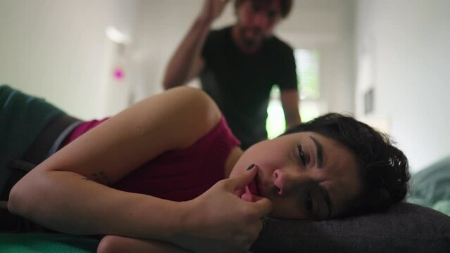 Depressed wife suffering from bad relationship while lying in bed listening to Angry husband yelling. Domestic abuse concept. Troubled in crisis in the verge of breakup